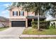 Two-story house with a large driveway and landscaped yard at 14949 Stonebriar Way, Orlando, FL 32826