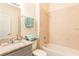 Simple bathroom with granite vanity, tub and shower, and neutral tile at 1784 Coriander Dr, Kissimmee, FL 34759