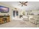 Living room features hardwood floors, a ceiling fan, and a large TV at 1855 S Lehigh Dr, Deltona, FL 32738