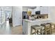 Modern kitchen island with seating, stainless steel appliances, and white cabinets at 2774 Puffin Pl, Davenport, FL 33837