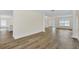 Open living room with hardwood floors, showing view into kitchen area at 415 Big Sioux Ct, Kissimmee, FL 34759