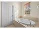 Bathroom with a large oval bathtub and window for natural light at 4459 Twinview Ln, Orlando, FL 32814