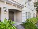 Inviting entryway with a dark brown door and lush greenery at 4775 Terrasonesta Dr, Davenport, FL 33837