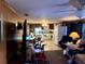 Living area with kitchen visible and seated person at 14917 Se 106Th Ave, Summerfield, FL 34491