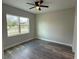 Bright bedroom with large window, ceiling fan, and wood-look flooring at 2426 Water St, Sanford, FL 32771