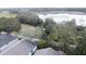 Aerial view of house and lush trees near a lake at 25001 Cranes Roost Cir, Leesburg, FL 34748