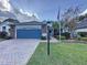House exterior with a paver driveway and American flag at 25001 Cranes Roost Cir, Leesburg, FL 34748
