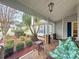 Relaxing front porch with wicker furniture and a view of the landscaped yard at 25001 Cranes Roost Cir, Leesburg, FL 34748