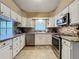 Modern kitchen featuring white cabinets, tile backsplash and stainless steel appliances at 25001 Cranes Roost Cir, Leesburg, FL 34748
