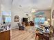 Open living room with hardwood floors, comfortable seating and a view to the sunroom at 25001 Cranes Roost Cir, Leesburg, FL 34748