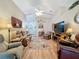 Spacious living room with hardwood floors, comfortable seating, and large TV at 25001 Cranes Roost Cir, Leesburg, FL 34748