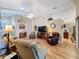 Bright living room featuring hardwood floors, a fireplace, and ample seating at 25001 Cranes Roost Cir, Leesburg, FL 34748