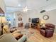 Spacious living area with hardwood floors, comfortable seating, and a large TV at 25001 Cranes Roost Cir, Leesburg, FL 34748