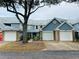 Blue-sided townhouses with white garages and landscaping at 4813 Coachmans Dr # 4, Orlando, FL 32812