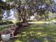 Relaxing community lawn with benches under large oak tree at 573 Lago Matisse St, Kissimmee, FL 34759