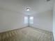 Well-lit bedroom with neutral carpeting and dual windows at 2553 Shanti Dr, Kissimmee, FL 34746