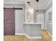 Basement wet bar with sliding barn door and pendant lighting at 333 N Spaulding Cv, Lake Mary, FL 32746
