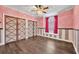 Pink bedroom with hardwood floors and window seat at 333 N Spaulding Cv, Lake Mary, FL 32746