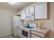 White kitchen cabinets, appliances, and tiled floors at 8709 Rockingham Ter # A, Kissimmee, FL 34747