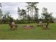 Relaxing fire pit area with brick fire pit and four wooden chairs at 2293 Eldorado Ct, St Cloud, FL 34771