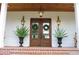Double front doors with lanterns and planters on a brick porch at 2293 Eldorado Ct, St Cloud, FL 34771