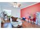 Living room with hardwood floors, red accent wall, and glass coffee table at 4213 Seybold Ave, Orlando, FL 32808