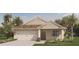 One-story home with beige siding, white garage door, and landscaped yard at 463 Taylor Groves Dr, Lake Wales, FL 33853