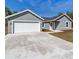 Gray house exterior with white garage door at 1041 Ne 130Th Ter, Silver Springs, FL 34488