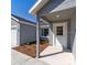 Front view of a gray house with a white door and landscaping at 1041 Ne 130Th Ter, Silver Springs, FL 34488