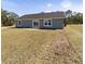 Back view of the gray house showing a large backyard at 1041 Ne 130Th Ter, Silver Springs, FL 34488