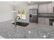 Kitchen boasts granite countertops and stainless steel fridge at 1041 Ne 130Th Ter, Silver Springs, FL 34488