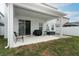 Covered patio with hanging chair and grill at 1949 Victoria St, Davenport, FL 33837