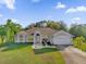 Single-story house with attached garage, manicured lawn, and palm trees at 3871 Dallas Blvd, Orlando, FL 32833