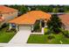 One-story house with a tile roof and driveway at 4027 Oakrise Loop, Davenport, FL 33837