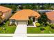One-story house with orange tile roof, driveway and green lawn at 4027 Oakrise Loop, Davenport, FL 33837