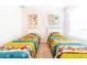 Well-lit bedroom with twin beds featuring colorful bedding and playful decor at 4027 Oakrise Loop, Davenport, FL 33837