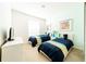 Bedroom with twin beds, teal and navy bedding, and cheerful wall art at 4027 Oakrise Loop, Davenport, FL 33837