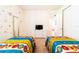 Bedroom with twin beds, dresser, TV, and access to another room at 4027 Oakrise Loop, Davenport, FL 33837