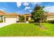 House exterior with two-car garage and manicured lawn at 4027 Oakrise Loop, Davenport, FL 33837