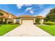 Single-story home with attached garage and manicured lawn at 4027 Oakrise Loop, Davenport, FL 33837