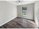 Well-lit bedroom featuring wood-look floors and ample space at 5933 Bible Camp Rd, Groveland, FL 34736