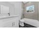 Clean bathroom with white vanity, tub, and gray tile at 6215 148Th Southwest, Ocala, FL 34473