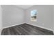 Simple bedroom with gray vinyl flooring and a window at 6215 148Th Southwest, Ocala, FL 34473