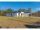 Single-story home with white exterior, black garage door, and a grassy yard at 6215 148Th Southwest, Ocala, FL 34473