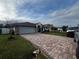House exterior showcasing a gray garage door and a brick paved driveway at 761 Americana Ct, Kissimmee, FL 34758