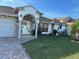 House exterior features stone accents, a paved driveway, and a well-manicured lawn at 761 Americana Ct, Kissimmee, FL 34758