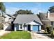 Charming one-story home with a blue garage door and well-manicured lawn at 9261 Lake Lotta Cir, Gotha, FL 34734