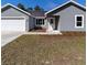 New construction home with gray siding, attached garage, and small landscaping at 13028 Ne 7Th Loop, Silver Springs, FL 34488