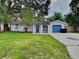 Charming single-story home with a landscaped lawn and blue garage door at 1440 Dann St, Orlando, FL 32804
