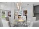 Open concept dining room with glass table and view into kitchen at 1473 Broken Oak Dr # C, Winter Garden, FL 34787